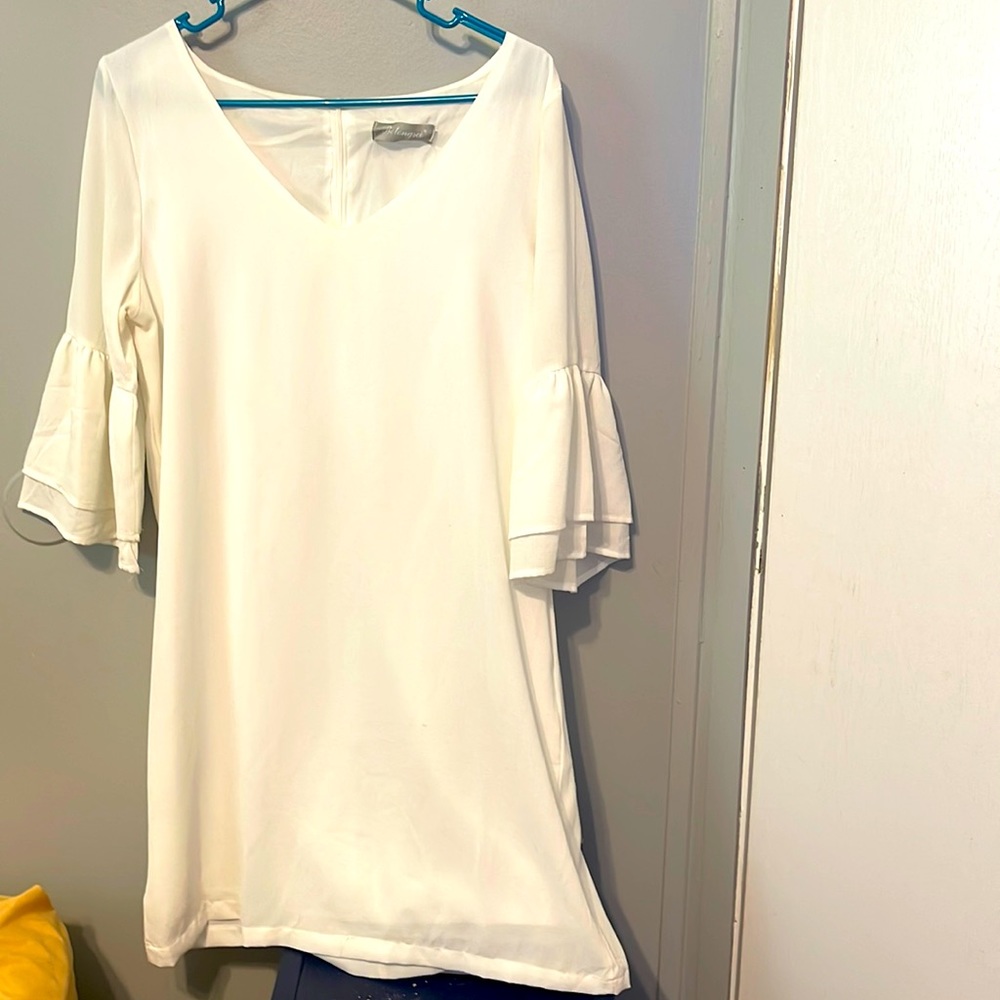 This little cutie petutie it is a medium flowing cream dress w/ ruffled sleeves